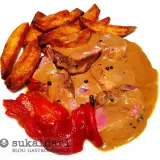 Delicioso solomillo a la pimienta bañado en salsa cremosa, acompañado de patatas rústicas y pimientos rojos asados.