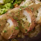 Jugoso solomillo de pollo relleno, bañado en salsa y acompañado de brócoli y zanahoria.
