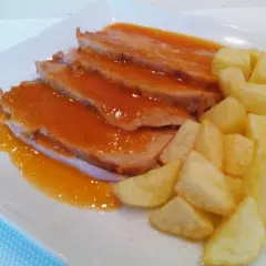 Jamon asado al horno, jugoso y tierno, bañado en salsa y acompañado de patatas fritas crujientes. ¡Un plato delicioso!