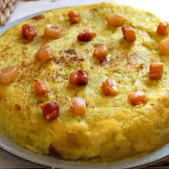 Un delicioso trinxat de la Cerdanya, una tortilla dorada con trocitos de panceta, lista para saborear.