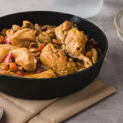 Sabroso pollo con almendras y verduras en una sartén, listo para servir.
