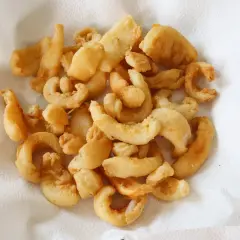 Un plato lleno de chocos fritos, crujientes y dorados, reposando sobre papel absorbente. ¡Un aperitivo delicioso!