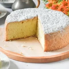 Un esponjoso pa de pessic, espolvoreado con azúcar glas, con una porción cortada.