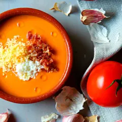 Salmorejo cremoso hecho en Thermomix, servido en cuenco de barro con huevo duro picado y taquitos de jamón.