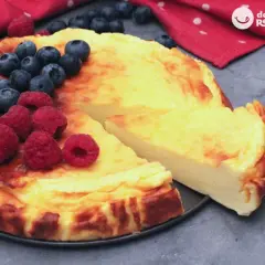 Tarta de yogur griego dorada, decorada con frambuesas y arándanos frescos. ¡Una delicia!