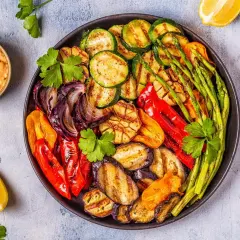 Plato de verduras a la brasa: calabacín, berenjena, pimientos, cebolla, espárragos y ajo, con un toque de limón y salsa.