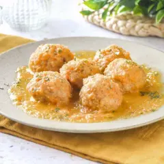 Sabrosas albóndigas de pollo en una salsa dorada, espolvoreadas con perejil fresco. Un plato casero listo para disfrutar.