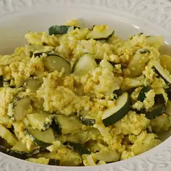 Zarangollo murciano, un plato casero de calabacín y huevo revuelto, servido en un cuenco blanco con relieve.