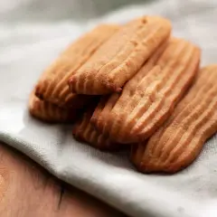 Galletas de mantequilla receta: deliciosas galletas doradas con surcos, apiladas sobre una tela clara.