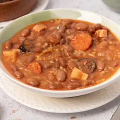 Un tazón humeante de alubias pintas con chorizo, patatas y arroz. Un plato reconfortante y sabroso.