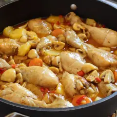 Estofado de pollo casero con patatas, champiñones y zanahorias en una sartén. Un plato reconfortante y delicioso.