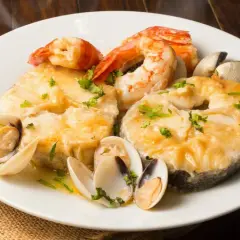 Merluza a la marinera con almejas y gambas, un plato delicioso y aromático, listo para disfrutar.