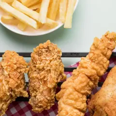 Crujientes alitas de pollo fritas y papas fritas doradas, un festín irresistible para cualquier amante de la comida rápida.