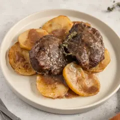 Deliciosas galtas al horno, tiernas y jugosas, servidas sobre rodajas de patata doradas y bañadas en su propia salsa.