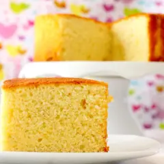 Un trozo de bizcocho de yogur, la receta de la abuela, esponjoso y dorado, sobre un plato blanco.