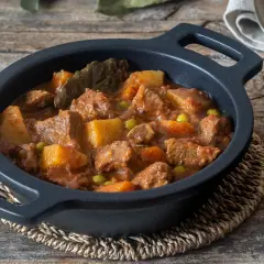 Un reconfortante estofado de ternera de la abuela, con trozos tiernos de carne, patatas y guisantes en una rica salsa.