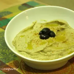 Un cremoso puré de berenjena con aceite de oliva y aceitunas negras, listo para disfrutar.