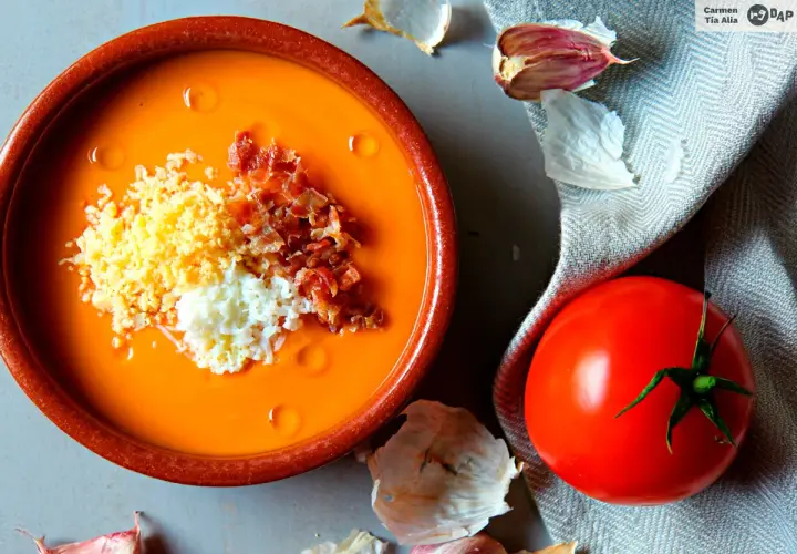 Salmorejo cremoso hecho en Thermomix, servido en cuenco de barro con huevo duro picado y taquitos de jamón.