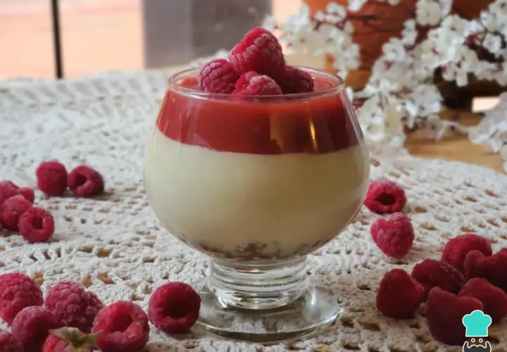 Deliciosa tarta de queso sin horno en copa, coronada con frambuesas frescas y coulis de frutos rojos.