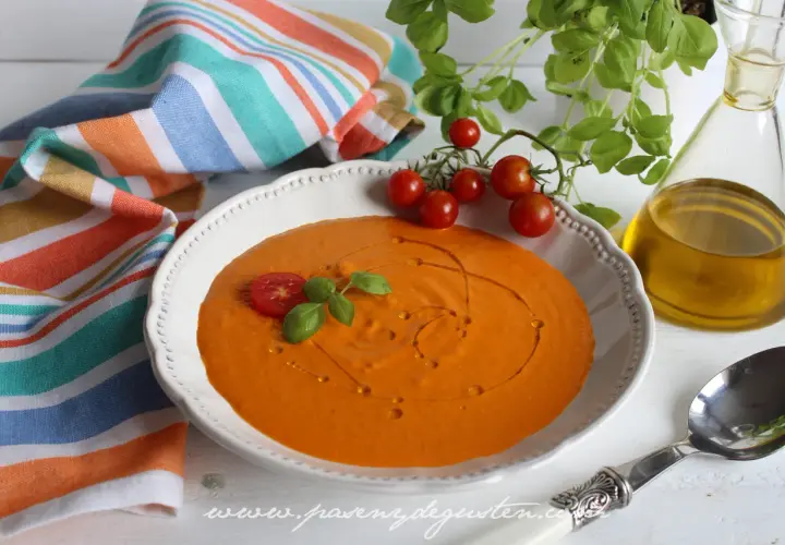 Crema de queso de tomate, decorada con tomates cherry y albahaca, lista para disfrutar.