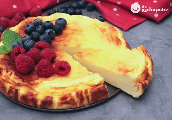 Tarta de yogur griego dorada, decorada con frambuesas y arándanos frescos. ¡Una delicia!