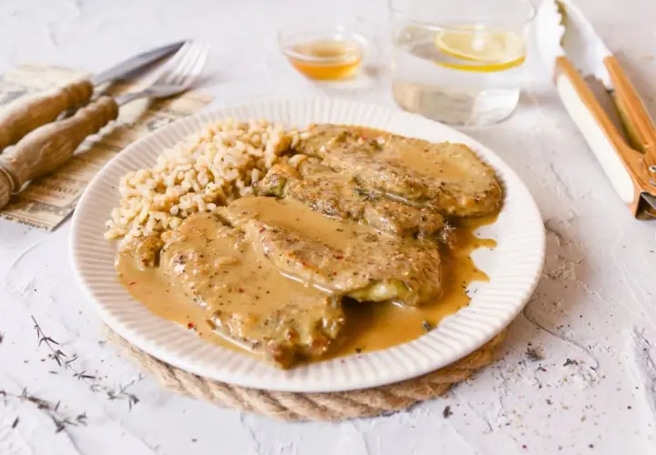 Escalopines de ternera en salsa cremosa con arroz. Un plato delicioso y reconfortante.