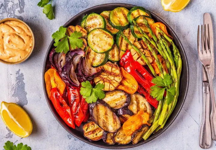 Plato de verduras a la brasa: calabacín, berenjena, pimientos, cebolla, espárragos y ajo, con un toque de limón y salsa.