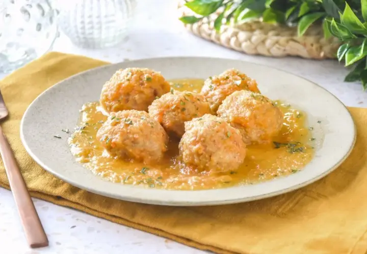 Sabrosas albóndigas de pollo en una salsa dorada, espolvoreadas con perejil fresco. Un plato casero listo para disfrutar.