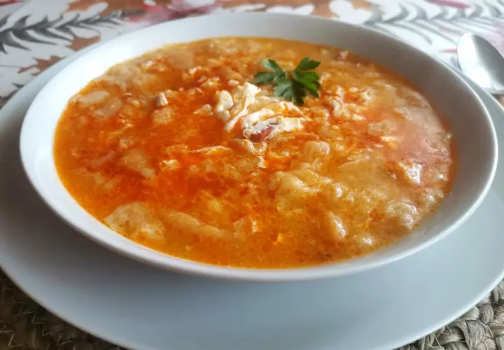 Un plato humeante de sopas de ajo receta, con huevo escalfado y perejil fresco.