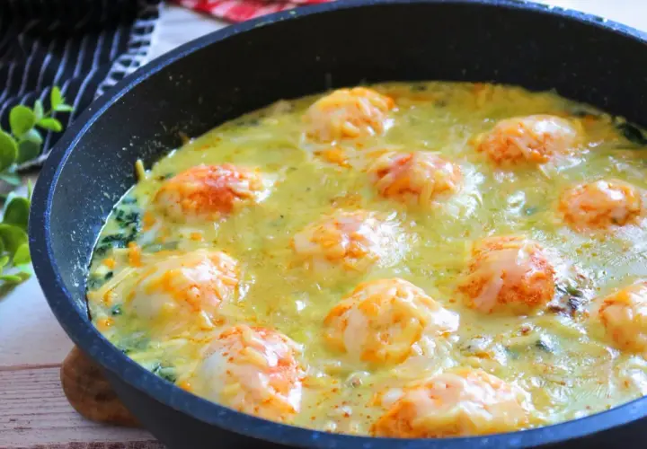 Deliciosos espinacas a la crema gratinadas con queso en una sartén.