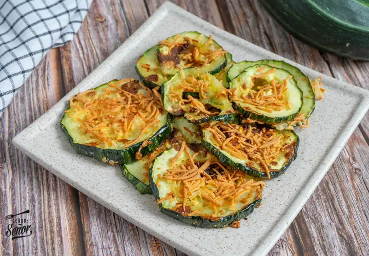 Rodajas de calabacín airfryer crujientes y doradas, espolvoreadas con queso rallado. ¡Un aperitivo saludable y delicioso!