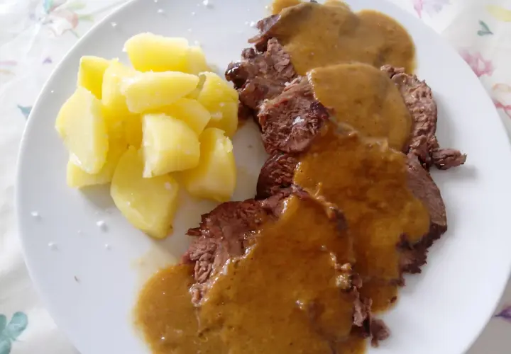 Tierna ternera asada en su jugo, servida con patatas cocidas. Un plato casero que reconforta.