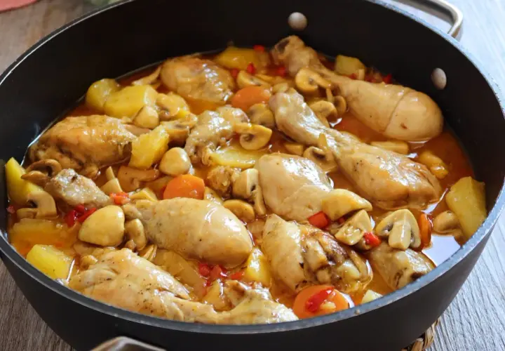 Estofado de pollo casero con patatas, champiñones y zanahorias en una sartén. Un plato reconfortante y delicioso.