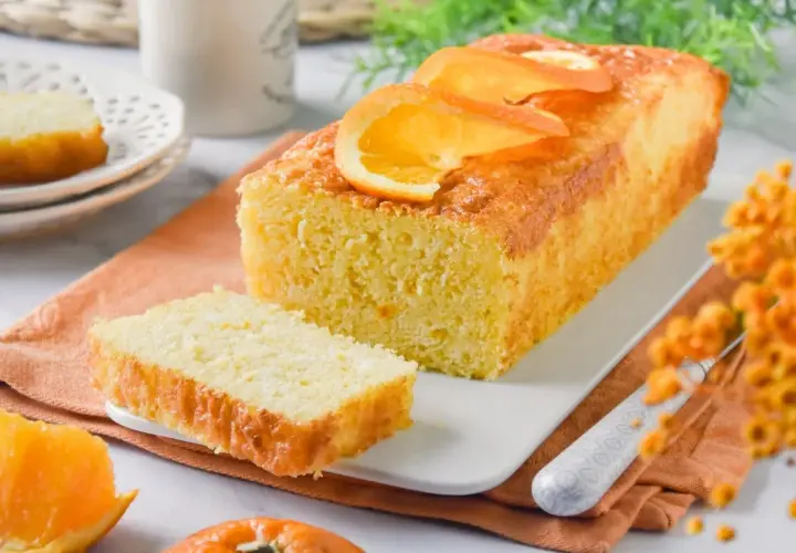 Un delicioso bizcocho de naranja, con rodajas de naranja fresca en la parte superior, listo para ser disfrutado.