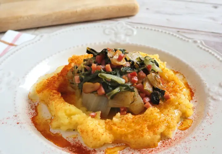 Puré de patatas cremoso con un sofrito de acelgas y trocitos de jamón, espolvoreado con pimentón. Un plato reconfortante de acelgas con patatas.