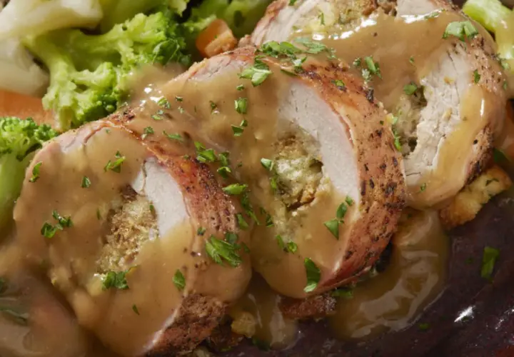 Jugoso solomillo de pollo relleno, bañado en salsa y acompañado de brócoli y zanahoria.