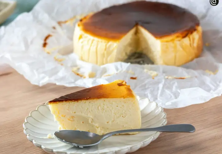 Deliciosa tarta de queso en freidora de aire, con una porción servida en plato y cuchara.