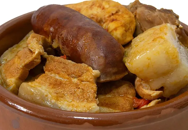 Un reconfortante puchero andaluz en cazuela de barro, con chorizo, tocino y trozos de carne.