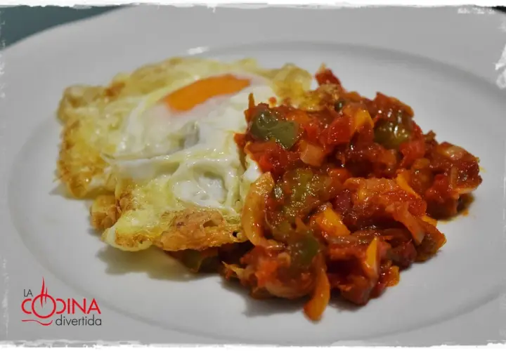Huevo frito con un sofrito de pimientos y tomate. Un plato sencillo y delicioso, perfecto para cualquier momento del día.