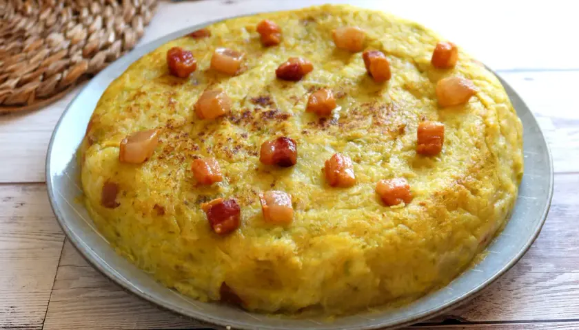 Un delicioso trinxat de la Cerdanya, una tortilla dorada con trocitos de panceta, lista para saborear.