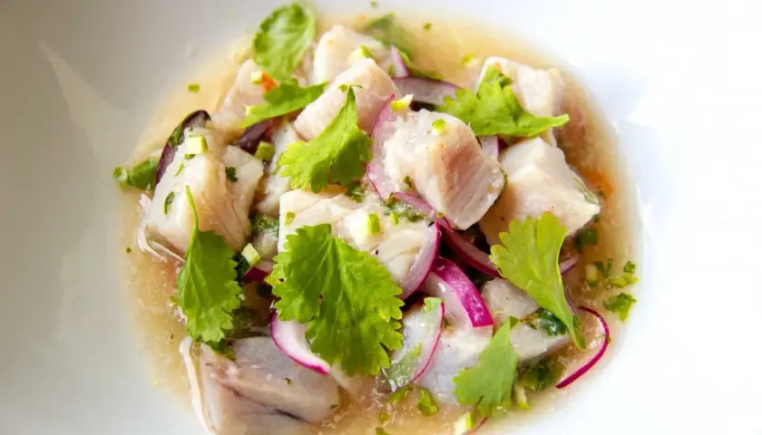 Delicioso ceviche de bonito, con trozos de pescado fresco, cebolla morada, cilantro y un toque cítrico.