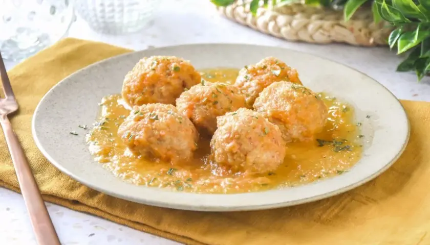 Sabrosas albóndigas de pollo en una salsa dorada, espolvoreadas con perejil fresco. Un plato casero listo para disfrutar.