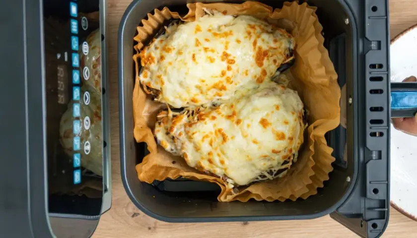 Dos berenjenas rellenas gratinadas con queso dorado, listas para disfrutar tras su paso por la airfryer.