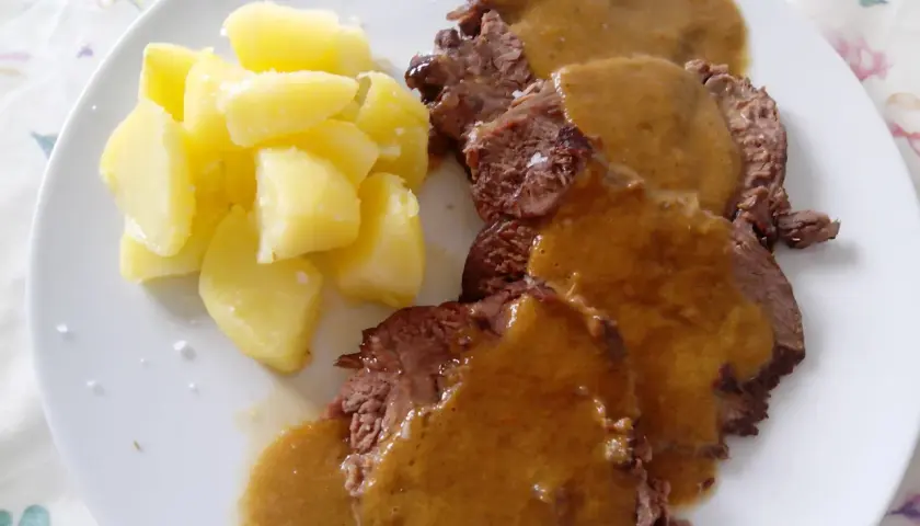 Tierna ternera asada en su jugo, servida con patatas cocidas. Un plato casero que reconforta.