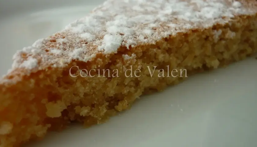 Rebanada de tarta de almendras esponjosa, espolvoreada con azúcar glas. ¡Un bocado delicioso!