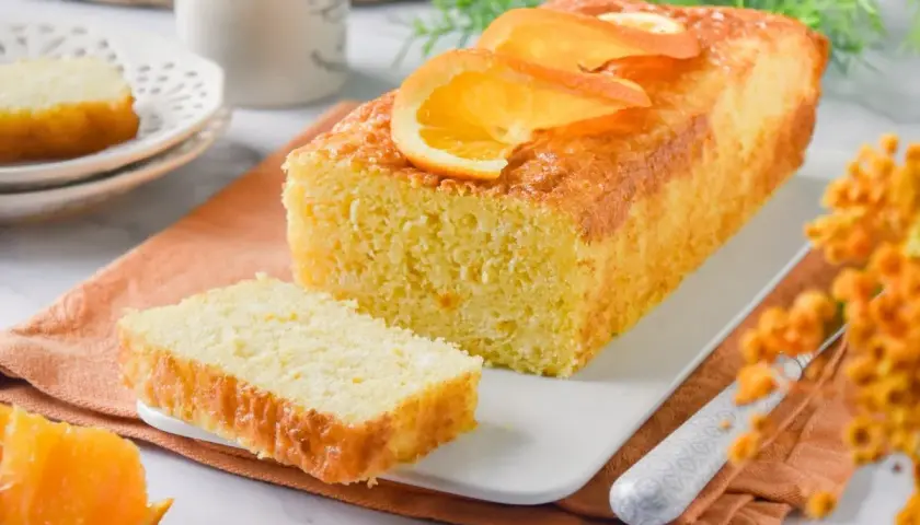 Un delicioso bizcocho de naranja, con rodajas de naranja fresca en la parte superior, listo para ser disfrutado.