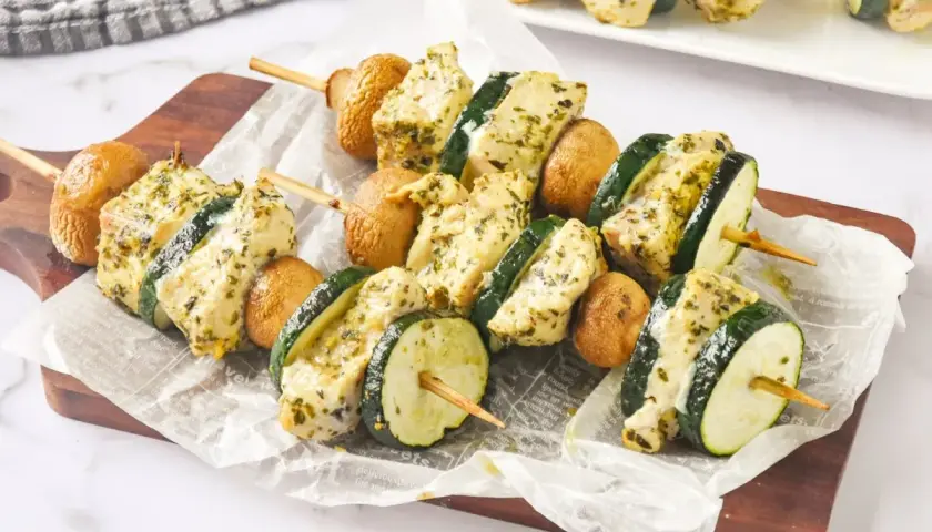 Brochetas de pollo marinadas con calabacín y champiñones, listas para asar.