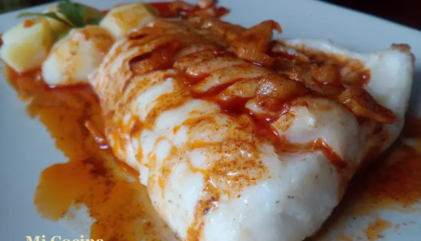 Un delicioso pescado rosado en salsa, acompañado de patatas.