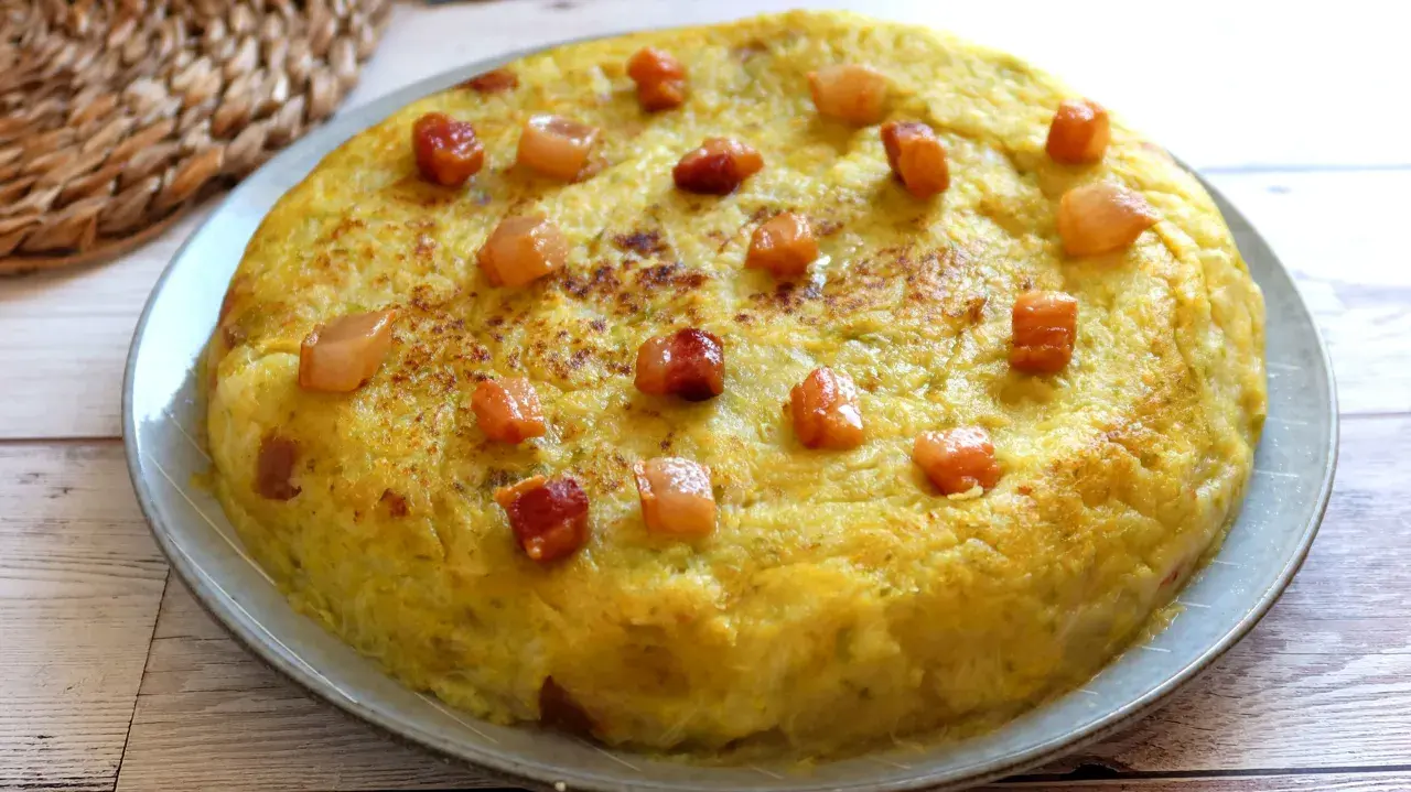Un delicioso trinxat de la Cerdanya, una tortilla dorada con trocitos de panceta, lista para saborear.