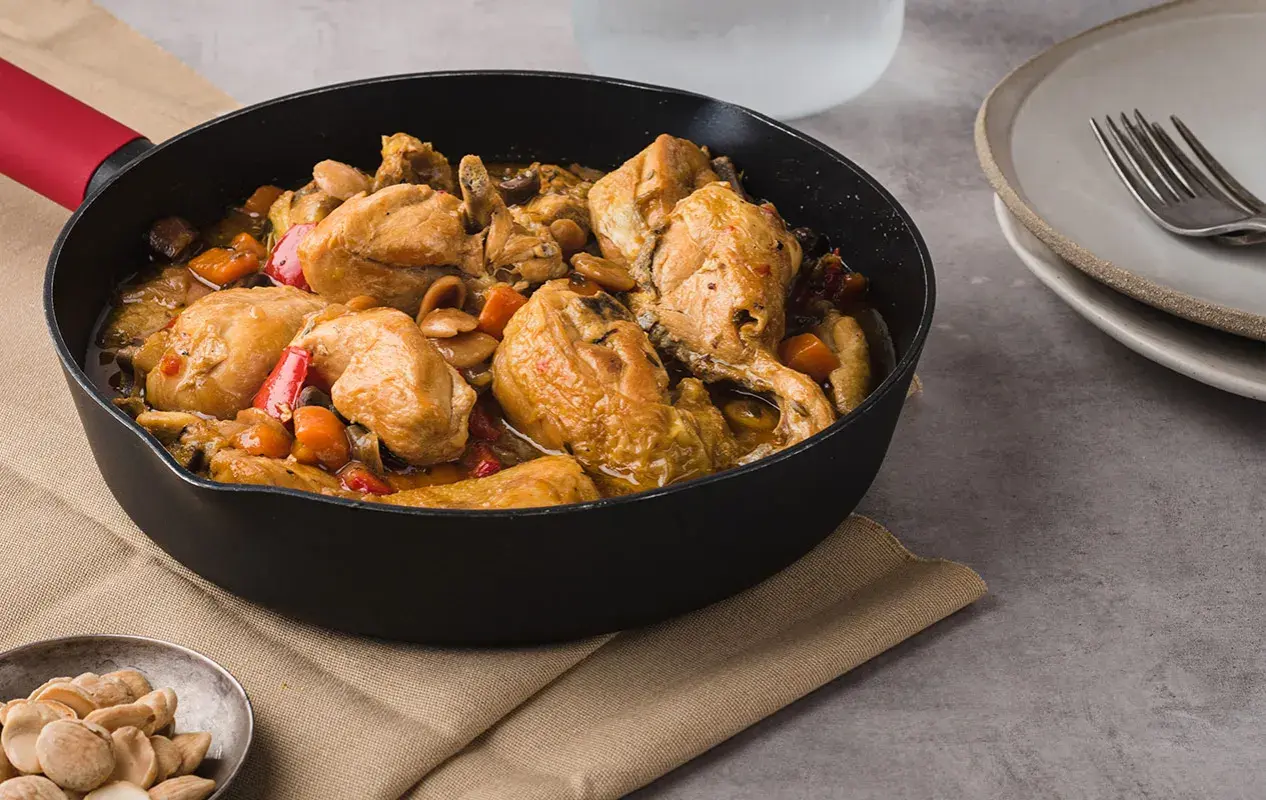 Sabroso pollo con almendras y verduras en una sartén, listo para servir.